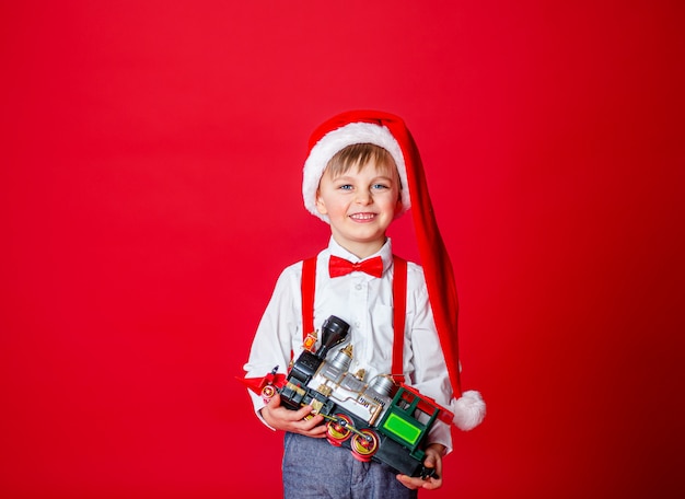 Feliz Natal. Menino alegre bonitinho no chapéu de Papai Noel