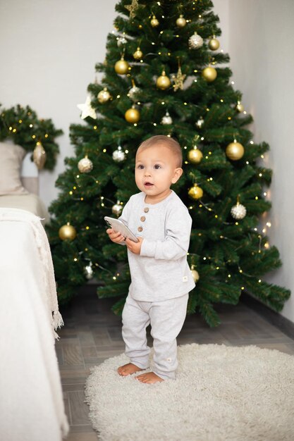 Feliz Natal Retrato de uma linda menina de um ano em um quarto aconchegante vestida para o estilo de vida do feriado