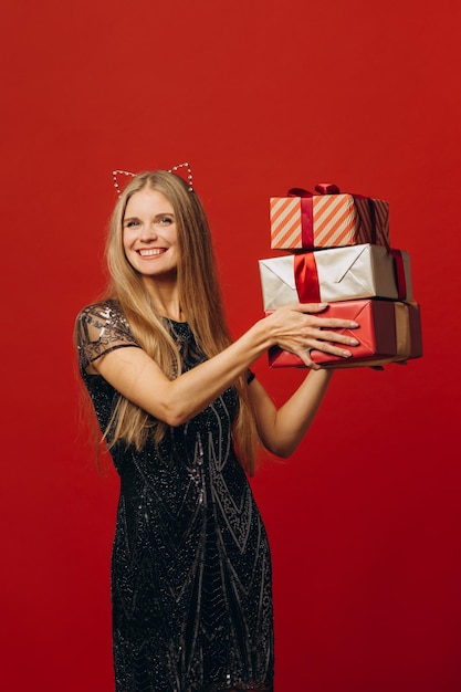 Feliz Natal, uma mulher loira feliz em um vestido festivo, segurando o retrato de presentes de Natal