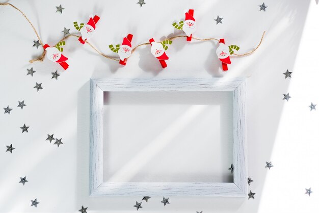 Feliz Navidad y año nuevo marco maqueta. Navidad santa, estrella de plata y marco blanco sobre blanco. Maqueta Flatlay