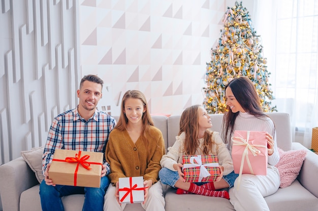 Feliz Navidad. Familia de cuatro con regalos de Navidad en casa