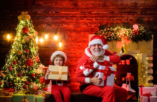 Feliz navidad felices fiestas hombre de santa claus y niño de santa en casa decoración navideña