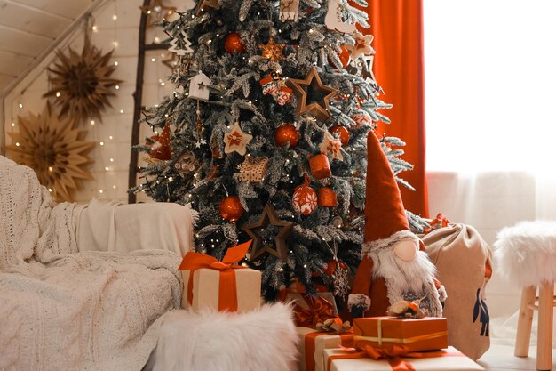 Feliz Navidad y felices fiestas. Interior de la elegante sala de estar con árbol de Navidad decorado y cómodo sofá. Año nuevo.