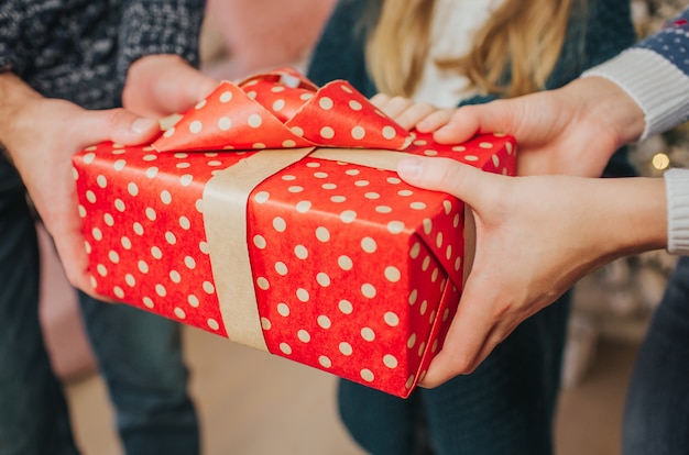 Feliz Navidad y felices fiestas Madre alegre, padre y su linda hija intercambiando regalos.