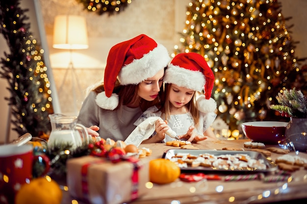 Feliz Navidad y felices fiestas. Madre e hija cocinar galletas de Navidad.