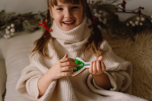 Feliz Navidad y Felices Fiestas. El niño juega con galletas de jengibre. Esperando la Navidad.