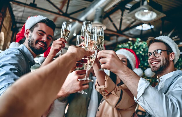 Foto feliz navidad y feliz año nuevo 2024los jóvenes creativos multirraciales están celebrando la fiesta en una oficina moderna