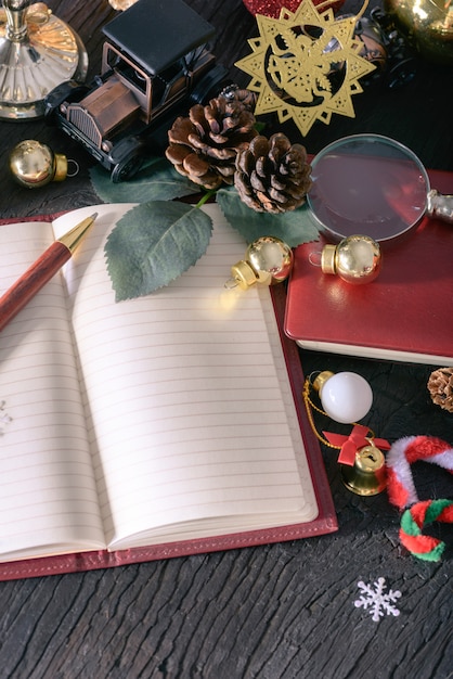 Foto feliz navidad y feliz año nuevo concepto con madera de pluma vintage de nota de libro y otra decoración