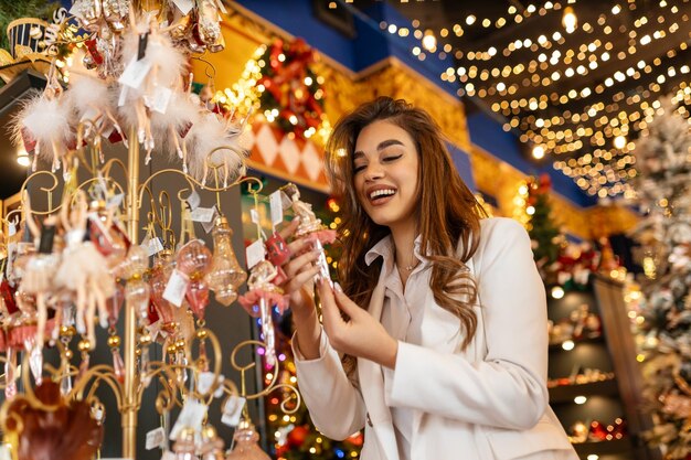 Foto feliz navidad y feliz año nuevo las mujeres llevan la decoración para el árbol de navidad con bolas y juguetes