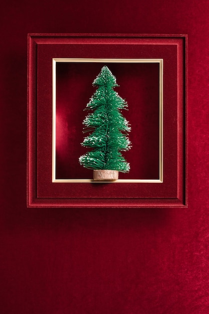 Feliz Navidad y feliz año nuevo texto y árbol de Navidad en marco de fotos de fieltro sobre tela de fieltro rojo terciopelo