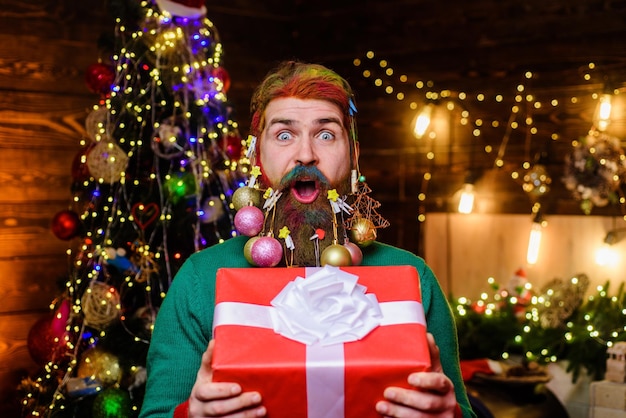 Feliz navidad feliz año nuevo vacaciones de invierno hombre barbudo con barba decorada de navidad sosteniendo