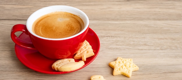 Feliz Navidad con galletas caseras y taza de café sobre fondo de mesa de madera. Víspera de Navidad, fiesta, vacaciones y feliz año nuevo concepto