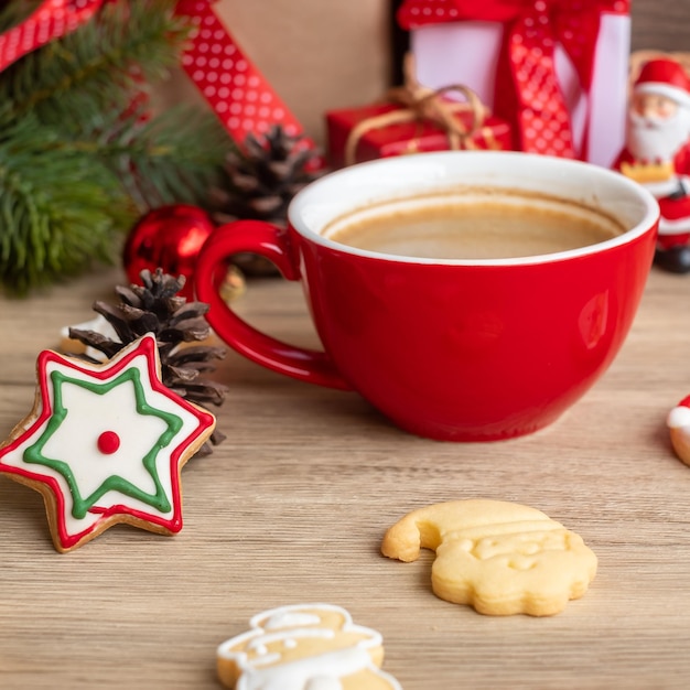 Feliz Navidad con galletas caseras y taza de café sobre fondo de mesa de madera. Víspera de Navidad, fiesta, vacaciones y feliz año nuevo concepto