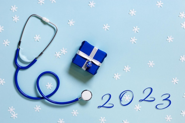 Feliz Navidad y próspero año nuevo concepto de medicina estetoscopio azul copos de nieve pequeña caja de regalo