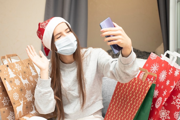 Feliz Navidad y próspero año nuevo una mujer joven con una máscara médica