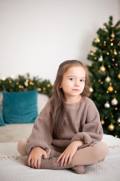 Feliz Navidad Retrato de una linda chica con un regalo en sus manos contra el fondo de un árbol de Navidad decorado Estilo de vida
