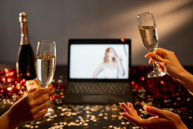 Foto feliz navidad saludo virtual conferencia en línea amigas brindando con una mirada de champán de vidrio