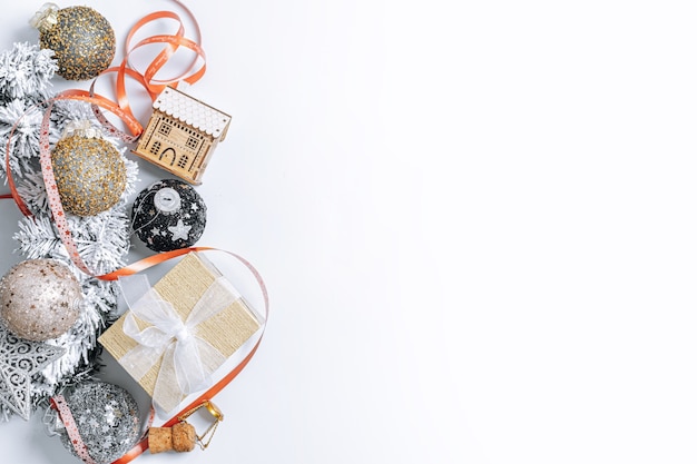 Feliz Navidad tarjetas de felicitación. Composición de Navidad y año nuevo con una caja de árbol de Navidad con un regalo Adornos navideños y juguetes en una vista superior de fondo blanco un lugar para sus felicitaciones.
