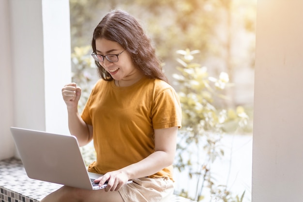 Feliz negócio bem sucedido de mulheres de negócios asiáticos freelance expressaram confiança encorajar trabalhando com computador portátil sentado em um banco de café como plano de fundo, comunicação