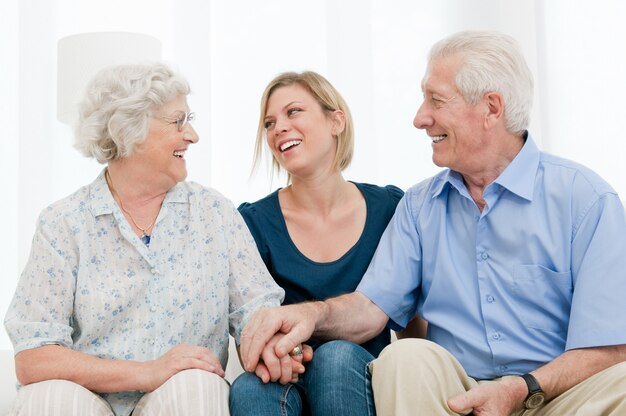 Feliz nieta sonriente quedarse con sus abuelos en casa