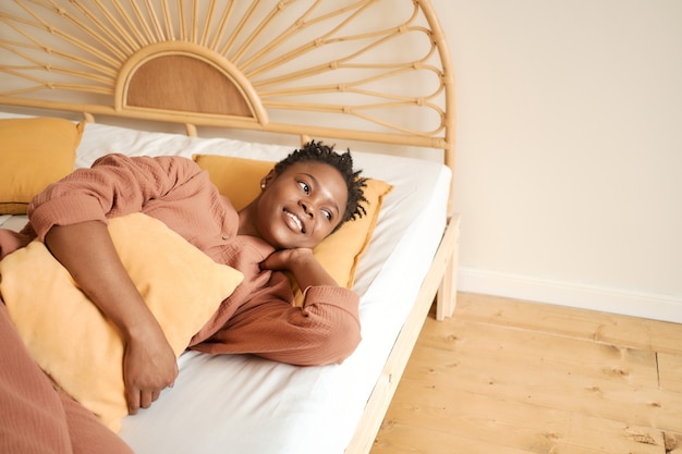 Feliz niña acostada en la cama disfruta de descanso