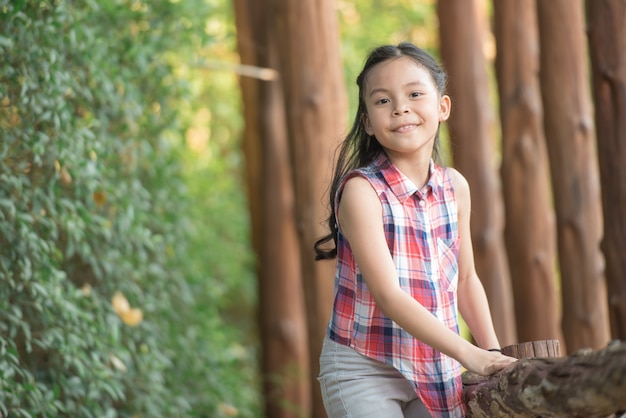 Foto feliz niña asiática divirtiéndose jugando en el patio de recreo en verano con una sonrisa y riendo sano, divertido rostro sonriente adorable adorable niña.