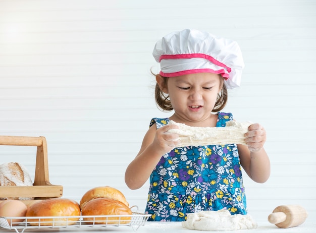 Foto feliz niña asiática haciendo una masa