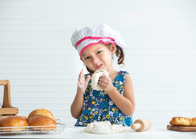 Foto feliz niña asiática haciendo una masa