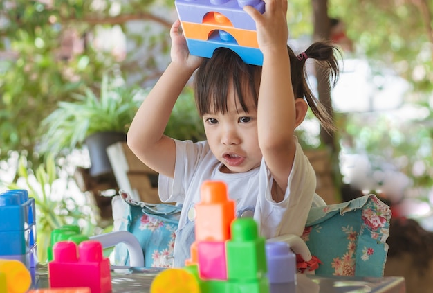 Feliz niña asiática jugando a los juguetes de bloques de plástico Aprendizaje y educación