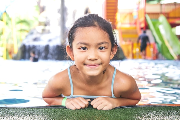 Feliz niña asiática en la piscina