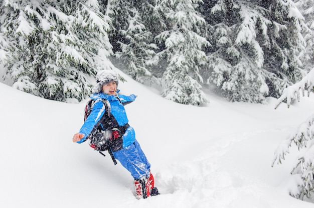 Feliz niña divertida salta en la nieve a la deriva