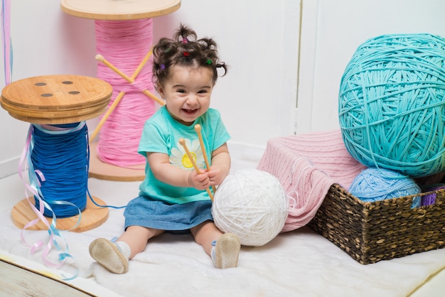 Feliz niña dulce sonriente sentada en el sofá, niña de cumpleaños, un año de edad