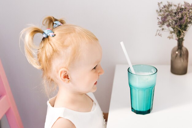 Feliz niña con estilo con un batido