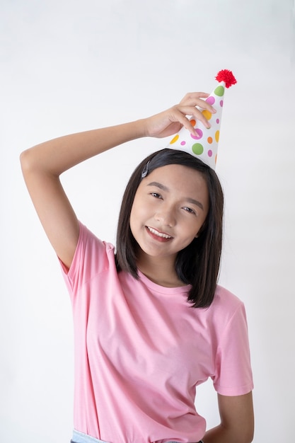 Feliz niña con gorro de fiesta sobre fondo blanco.