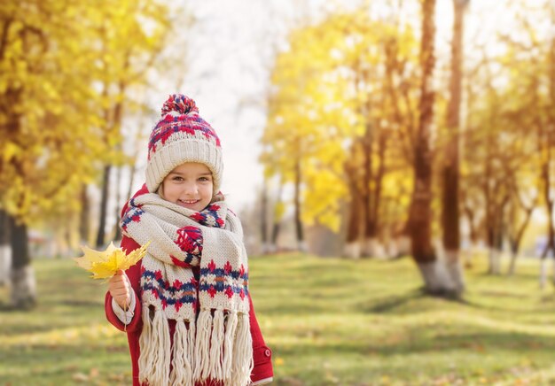 Feliz niña hermosa en el parque otoño