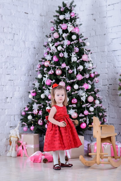 Feliz niña linda cerca del árbol de Navidad