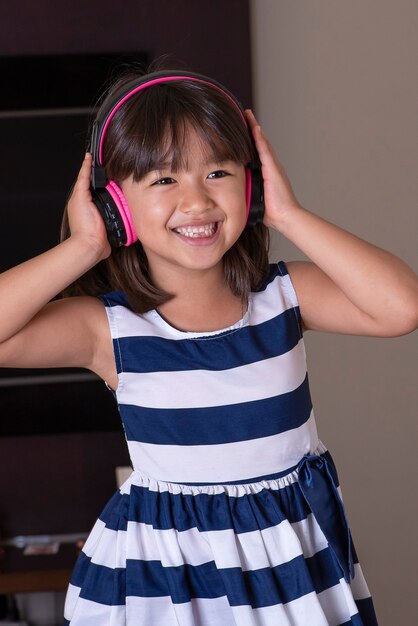 Foto feliz niña linda escuchando música