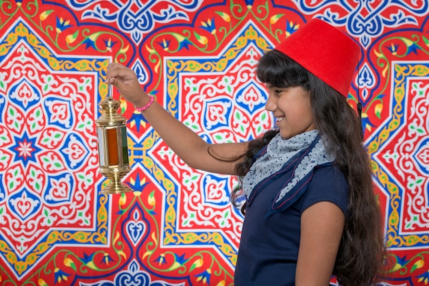 Feliz niña mirando la linterna celebrando el Ramadán