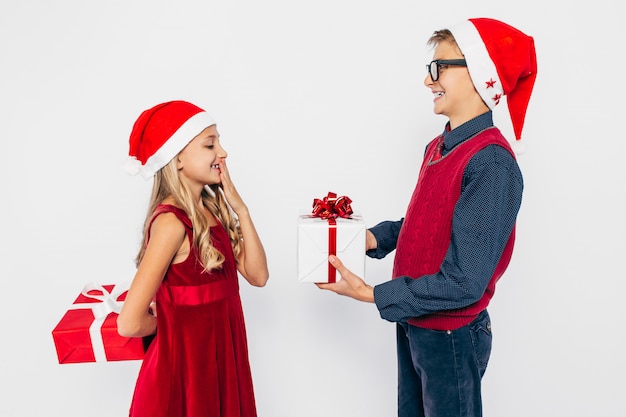 Feliz niña y niño con sombrero de Santa, elegante hermano y hermana