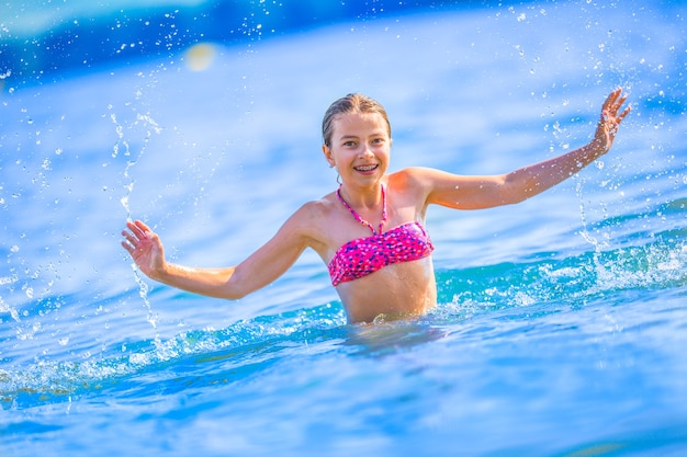 Feliz niña preadolescente disfruta de agua de verano y vacaciones en destinos de vacaciones