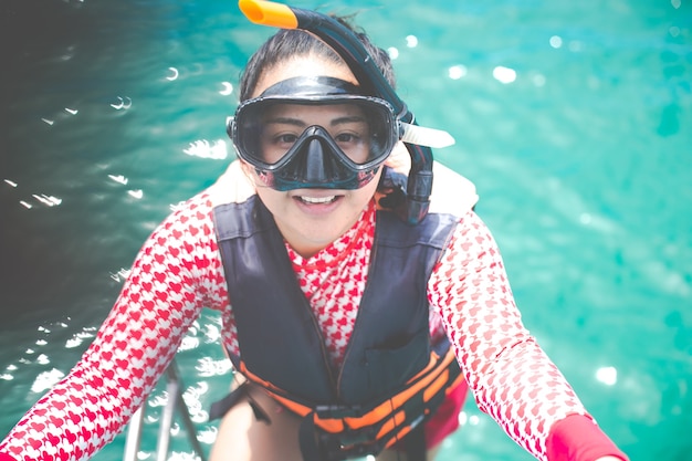 Feliz niña de snorkel divirtiéndose en el agua del océano snorkel en vacaciones caribeñas en Tailandia