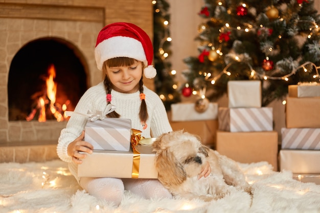 Feliz niña con sombrero de santa tiene navidad