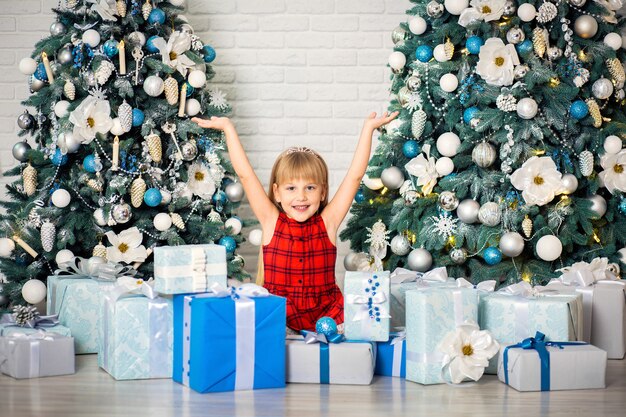 Feliz niña sonriente con caja de regalo de Navidad.