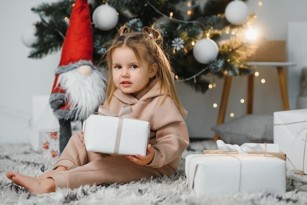 Feliz niña sonriente con caja de regalo de Navidad.