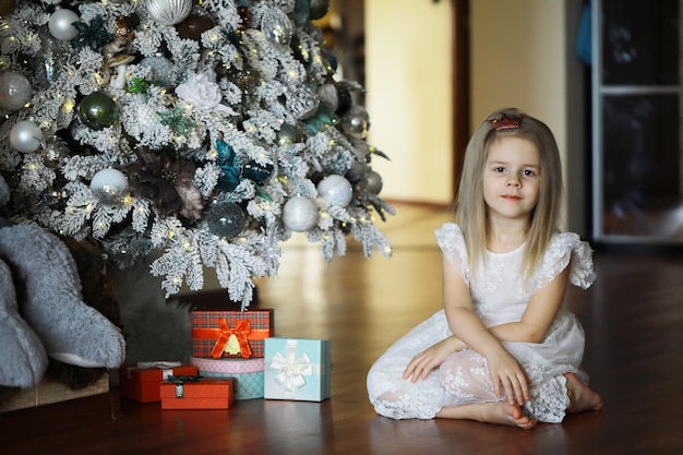 Feliz niña sonriente con caja de regalo de navidad