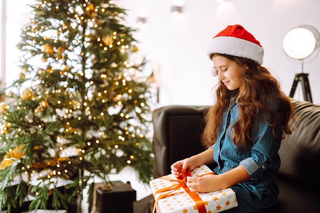 Feliz niña sonriente con cajas de regalo de Navidad. Niño lindo se divierte cerca del árbol.