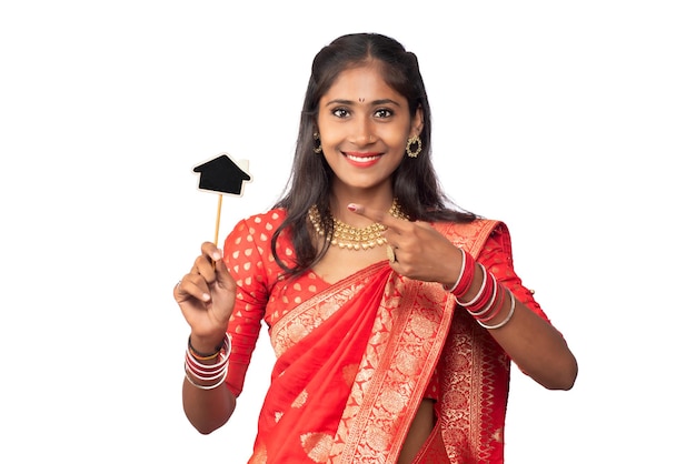 Feliz niña tradicional india sosteniendo una pequeña tabla cortada en sus manos sobre un fondo blanco