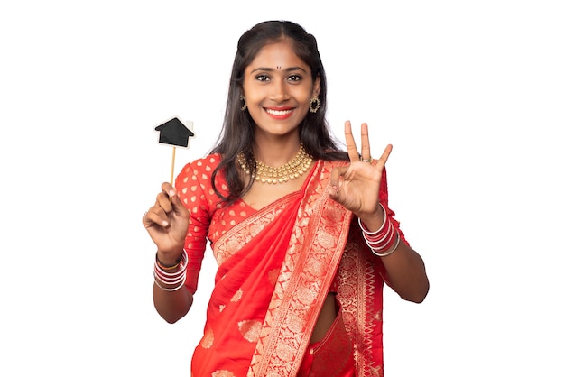 Feliz niña tradicional india sosteniendo una pequeña tabla cortada en sus manos sobre un fondo blanco