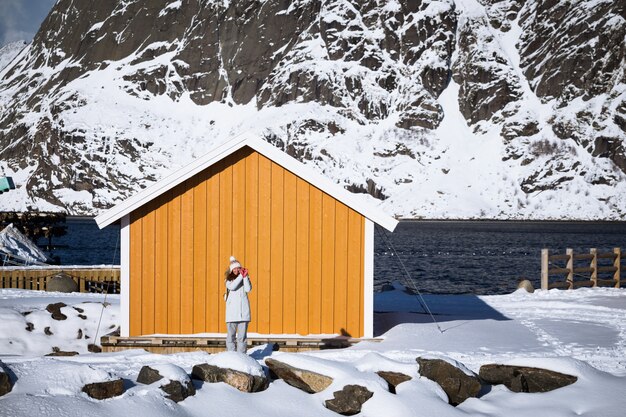 Feliz niña turística sonriente cerca de rorbu. Islas Lofoten. Noruega