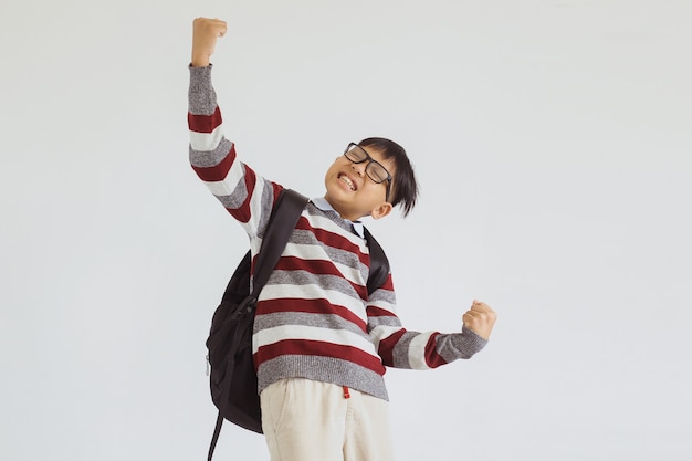 Feliz niño asiático emocionado de dar la bienvenida a la escuela